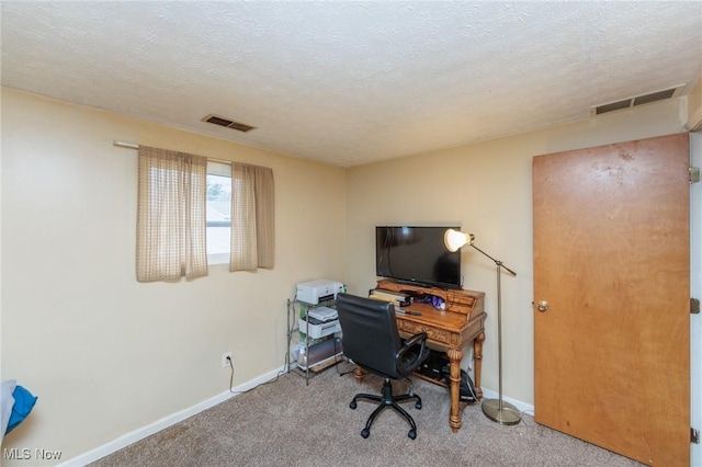 carpeted home office with visible vents, a textured ceiling, and baseboards