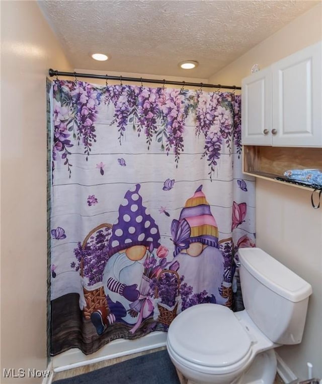 bathroom featuring toilet, recessed lighting, a textured ceiling, and a shower with shower curtain