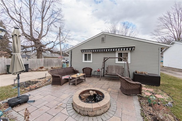 rear view of house featuring an outdoor living space with a fire pit, fence, and a patio