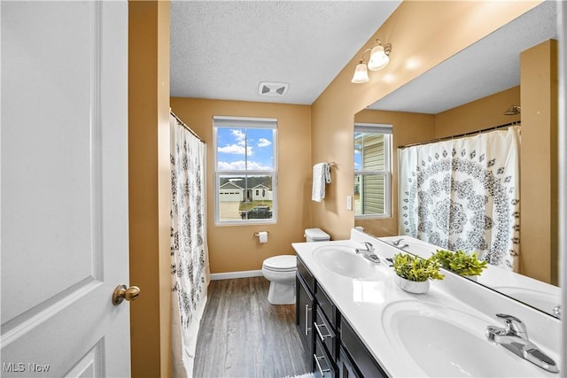 full bathroom with toilet, wood finished floors, baseboards, and a sink