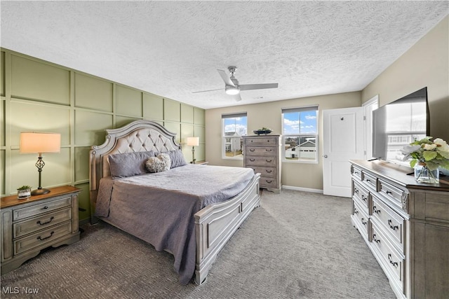 bedroom featuring ceiling fan, carpet, and a textured ceiling