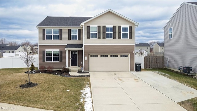 traditional-style home featuring driveway, an attached garage, a front yard, and fence