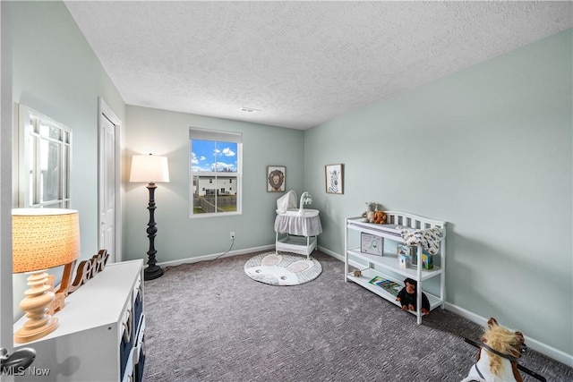 recreation room featuring carpet flooring, baseboards, and a textured ceiling