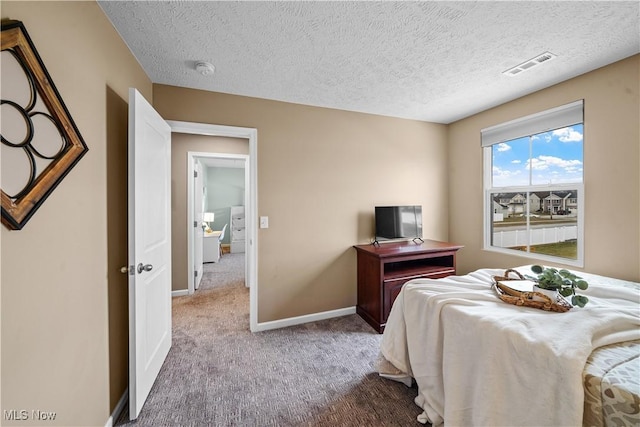 bedroom with visible vents, baseboards, carpet, and a textured ceiling