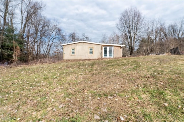 view of side of property featuring french doors and a lawn