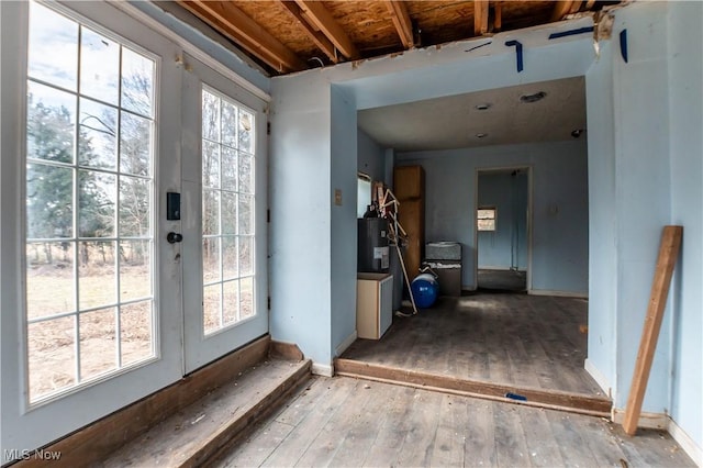 entryway with wood-type flooring, baseboards, and electric water heater