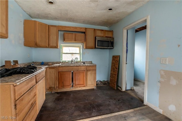 kitchen with stainless steel microwave, a sink, and brown cabinetry