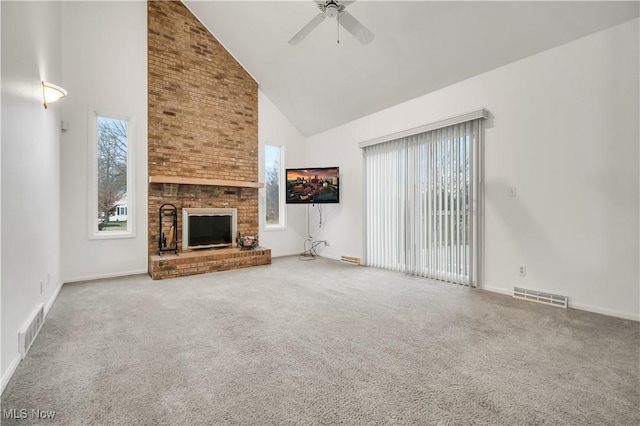 unfurnished living room with high vaulted ceiling, a fireplace, carpet flooring, and visible vents