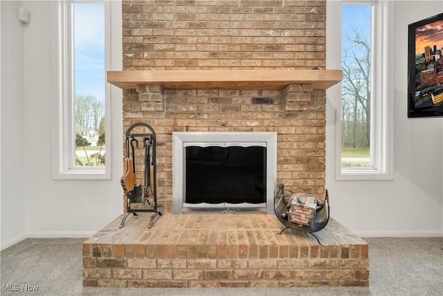 interior details featuring carpet, a brick fireplace, and baseboards