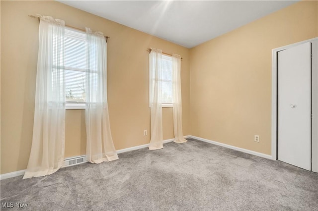 carpeted empty room with baseboards