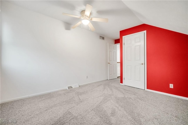 unfurnished bedroom featuring vaulted ceiling, carpet flooring, visible vents, and baseboards