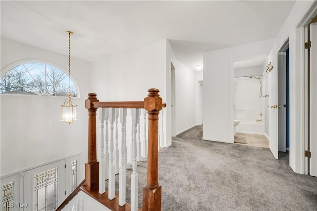 hallway with a notable chandelier and carpet flooring