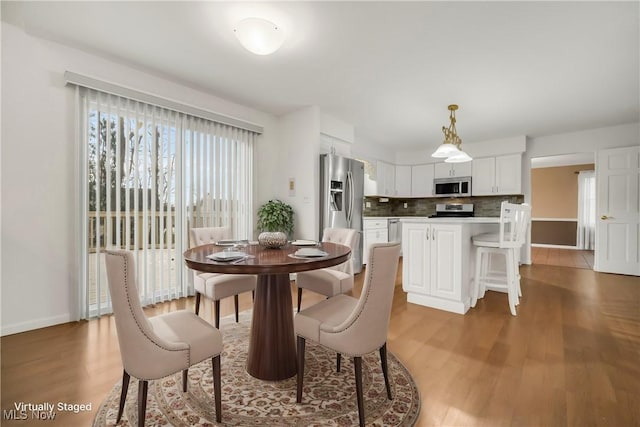 dining room featuring light wood-style flooring and baseboards