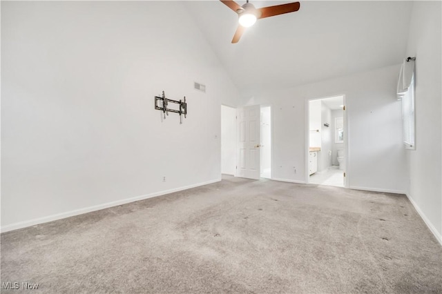 unfurnished bedroom with carpet, visible vents, ensuite bathroom, high vaulted ceiling, and baseboards