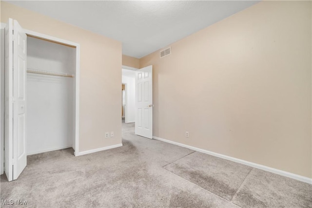 unfurnished bedroom with carpet floors, baseboards, visible vents, and a closet