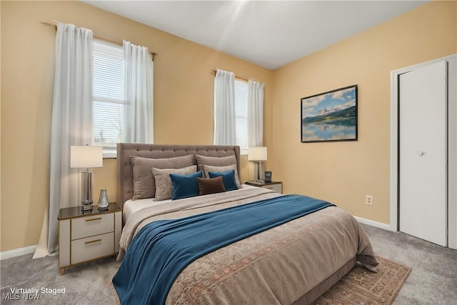 bedroom with light carpet and baseboards