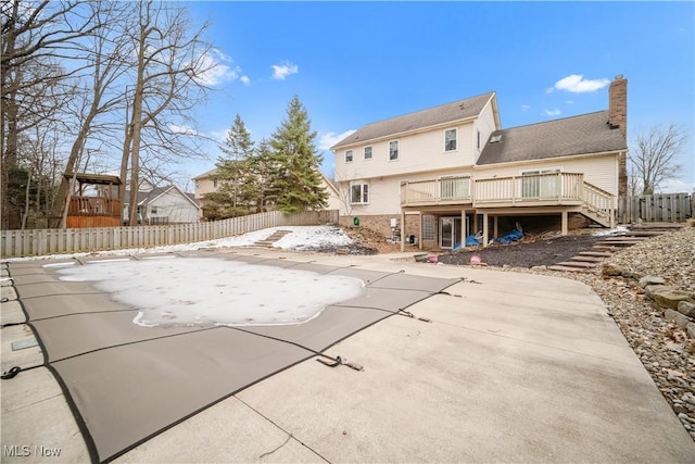 rear view of house with a patio, a chimney, stairway, a deck, and a fenced backyard