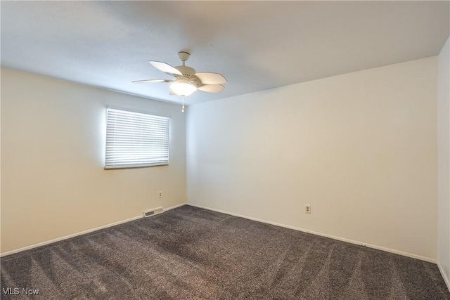 unfurnished room featuring baseboards, dark colored carpet, visible vents, and a ceiling fan