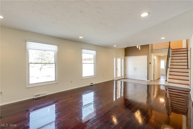 unfurnished living room featuring stairs, baseboards, wood finished floors, and recessed lighting