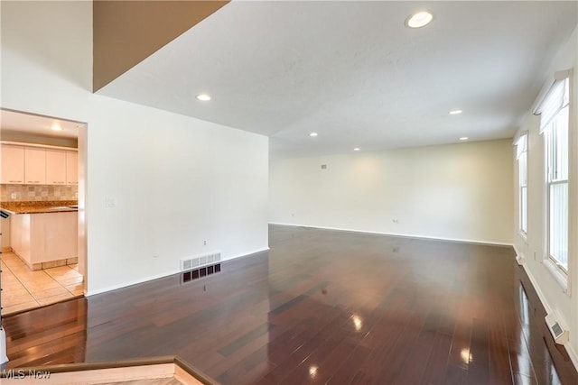 spare room featuring baseboards, wood finished floors, visible vents, and recessed lighting