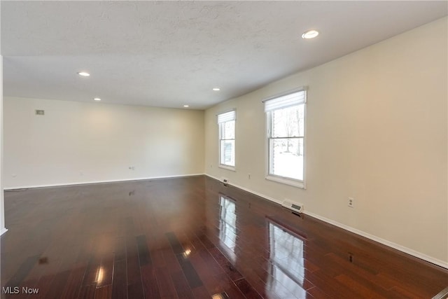 empty room with visible vents, baseboards, wood finished floors, and recessed lighting