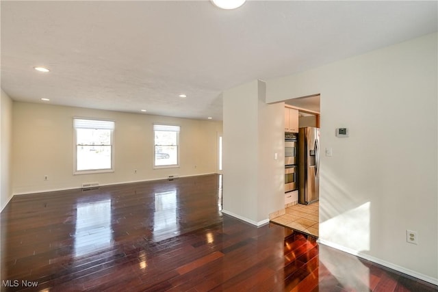 unfurnished room with recessed lighting, baseboards, visible vents, and hardwood / wood-style floors