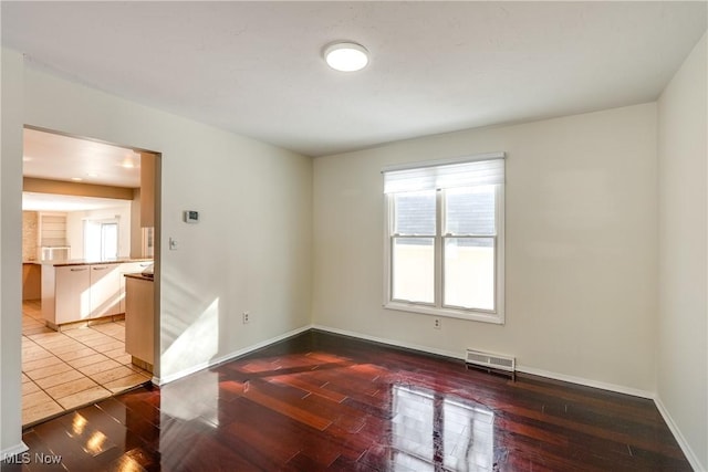 unfurnished room with visible vents, baseboards, and wood finished floors