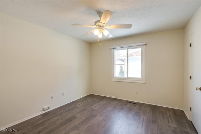 unfurnished room with ceiling fan, baseboards, and dark wood finished floors