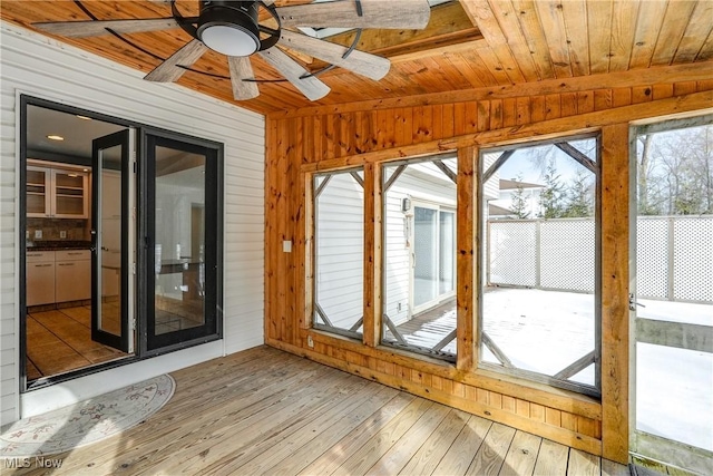 unfurnished sunroom with ceiling fan, wood ceiling, and vaulted ceiling