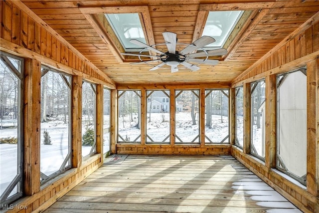 unfurnished sunroom featuring ceiling fan, lofted ceiling with skylight, and wood ceiling