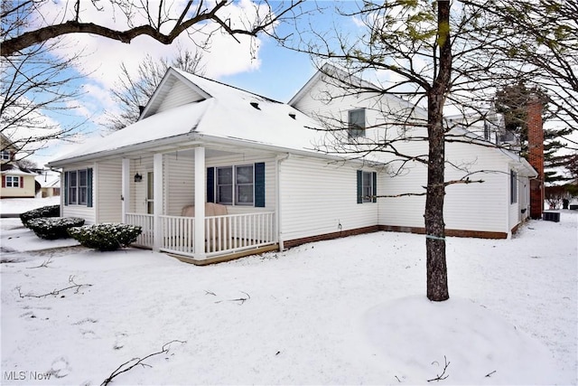 snow covered property featuring covered porch