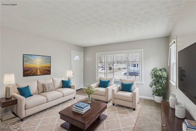 living room featuring baseboards, a textured ceiling, and light colored carpet