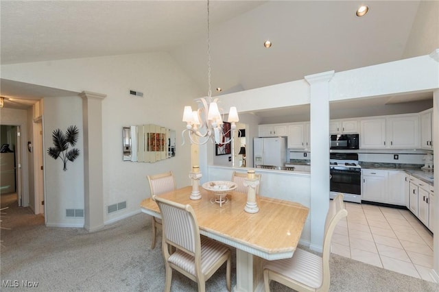 dining space with decorative columns, visible vents, a chandelier, and light colored carpet