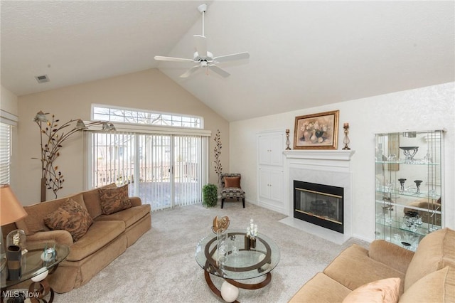 living area with visible vents, light colored carpet, ceiling fan, vaulted ceiling, and a fireplace