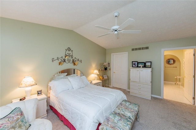 carpeted bedroom with visible vents, vaulted ceiling, baseboards, and ceiling fan