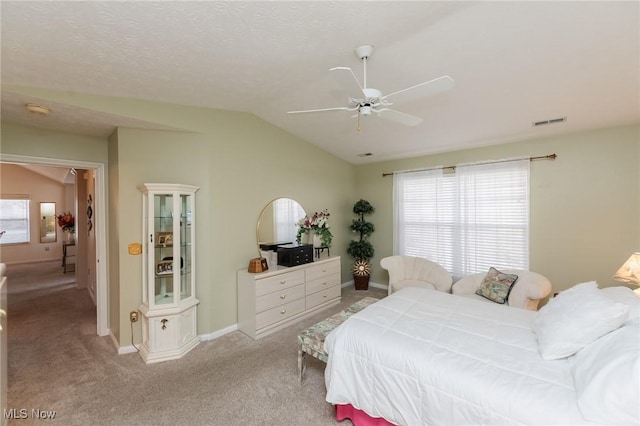 bedroom featuring vaulted ceiling, multiple windows, light carpet, and visible vents