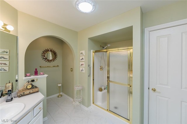 bathroom with a shower stall, vanity, and baseboards