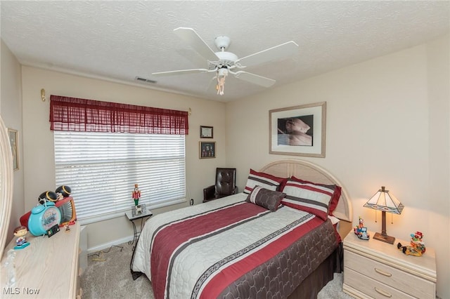 bedroom featuring ceiling fan, a textured ceiling, visible vents, and carpet flooring