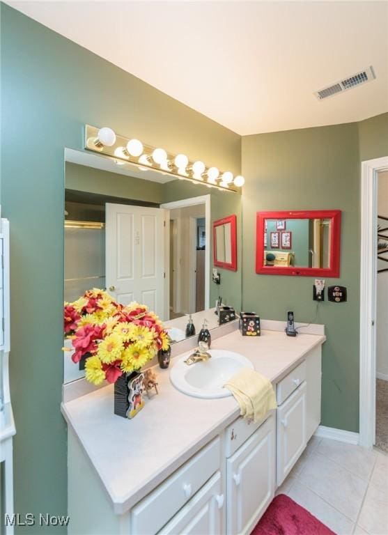 bathroom with vanity, tile patterned flooring, visible vents, and baseboards