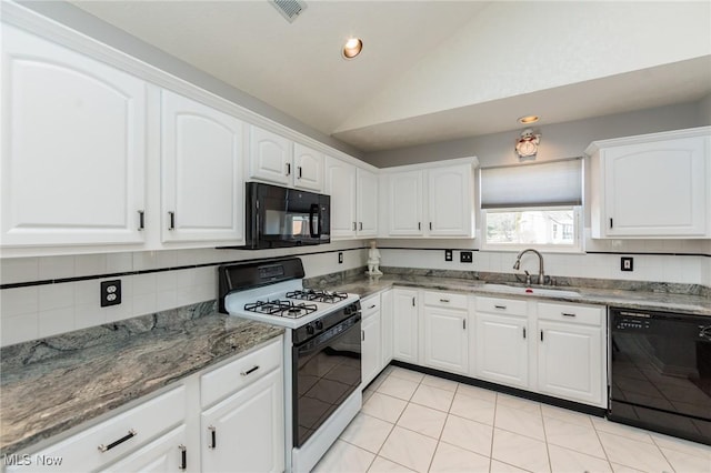 kitchen with white cabinets, vaulted ceiling, a sink, dark stone counters, and black appliances