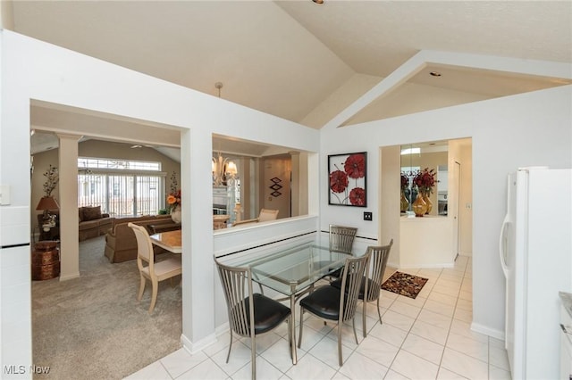 dining room with lofted ceiling, light tile patterned floors, a notable chandelier, and light colored carpet