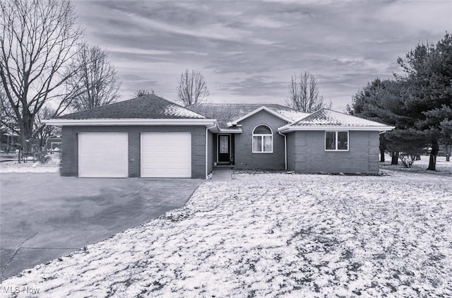 ranch-style house featuring a garage and aphalt driveway