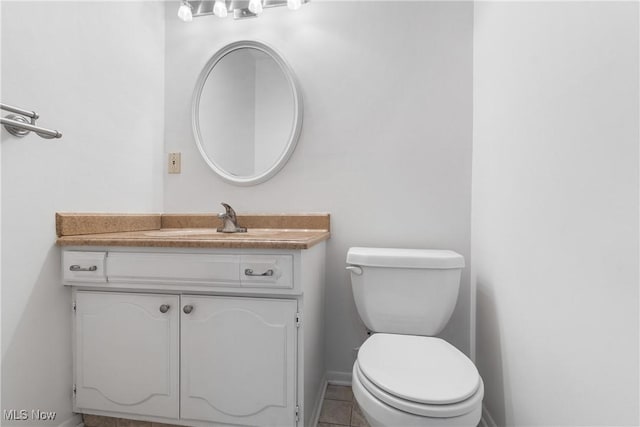 bathroom featuring toilet, tile patterned flooring, and vanity