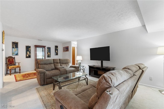 living area featuring light carpet and a textured ceiling