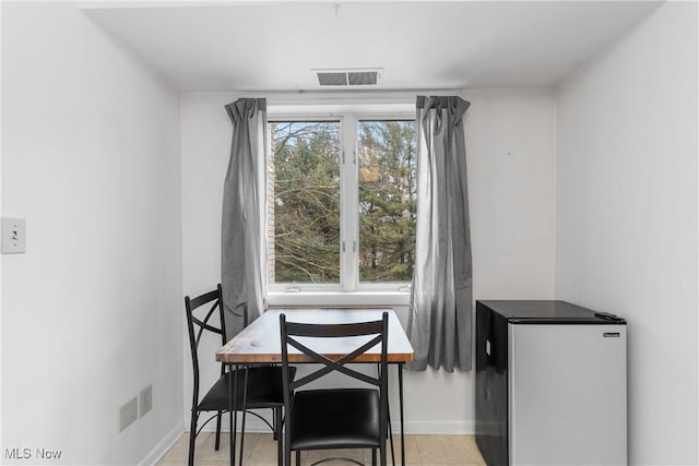 dining space featuring light tile patterned floors, baseboards, and visible vents