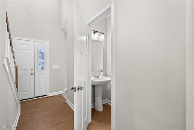 interior space featuring a sink, baseboards, and wood finished floors