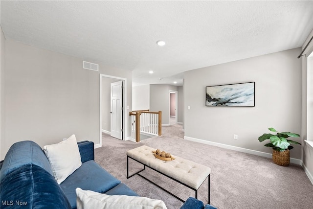 living room with carpet floors, a textured ceiling, and baseboards