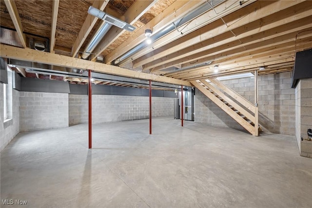 unfinished basement featuring stairs