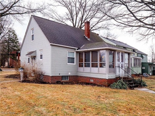 exterior space with a yard, a shingled roof, a chimney, and a sunroom