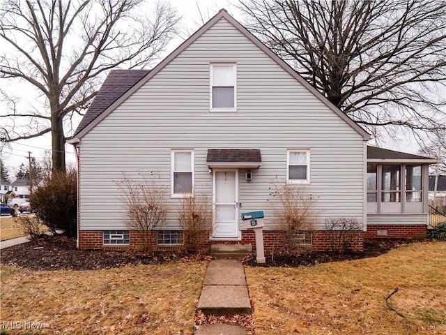 view of front of property with a front yard and a sunroom